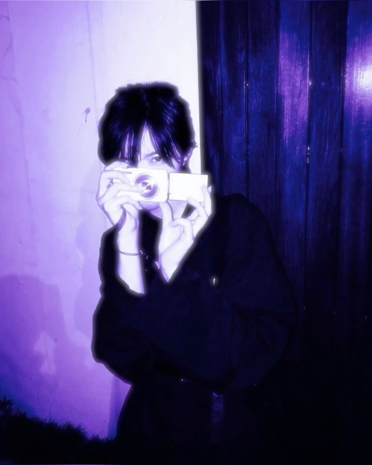 Person holding a camera in violet light