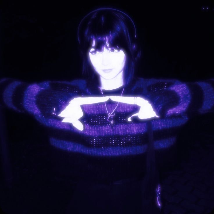 Portrait wearing headphones with hands making a triangle in violet light